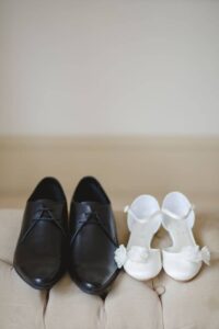 کفش های کوچک دختری که عروس است به همراه کفش های داماد که نشان از کودک بودن عروس دارد.